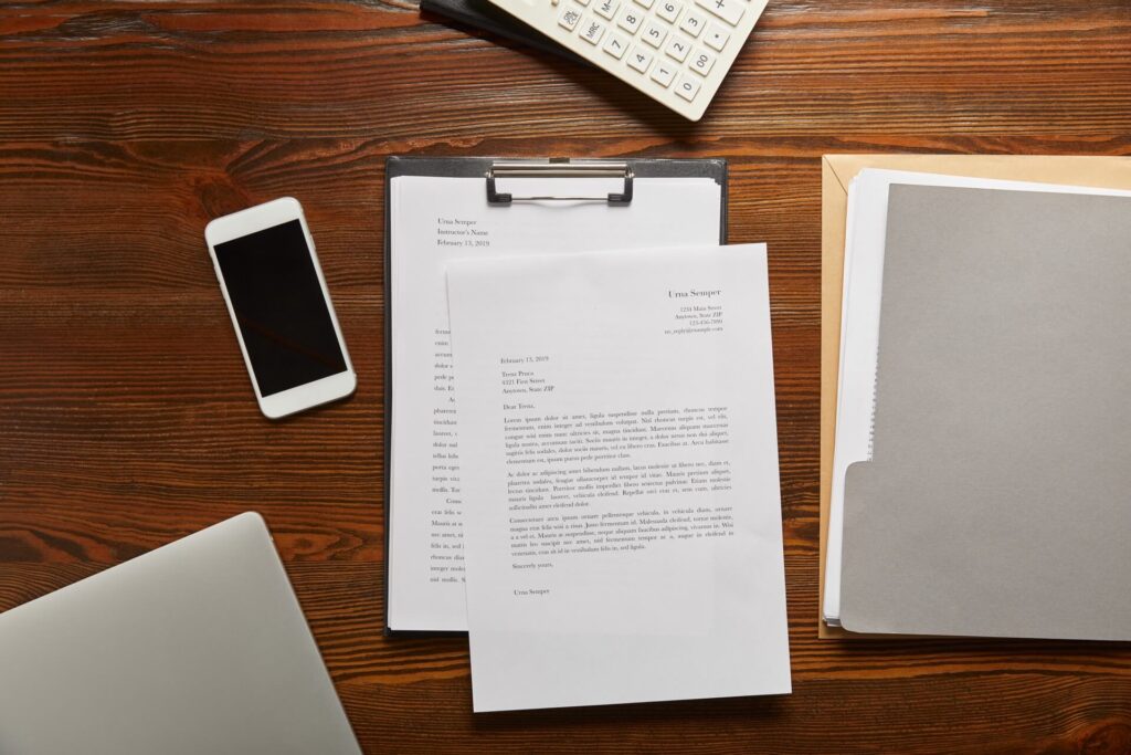 Documents on a table next to a smart phone